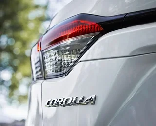 Close-up of the taillight and Corolla badge on a white Toyota Corolla