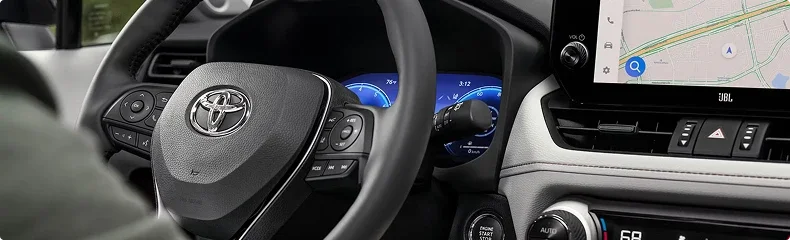 Close-up of a Toyota steering wheel, digital gauge cluster and touchscreen navigation display
