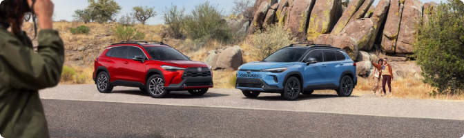 Red and blue 2026 Toyota Corolla Cross models parked side by side at a desert overlook