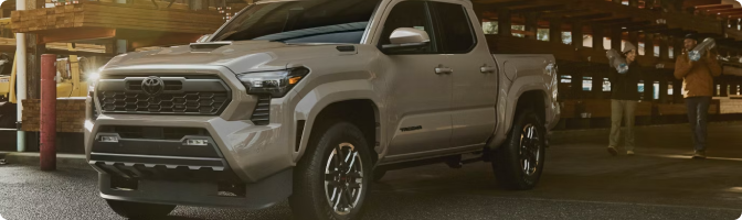 Silver 2026 Toyota Tacoma Double Cab parked in a lumber yard at dusk