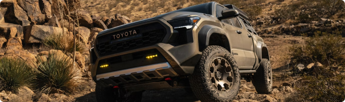 2026 Toyota Tacoma Trailhunter with amber fog lights on a rocky desert trail